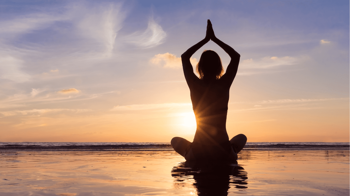 Frau macht Yoga am Strand: 18 Schritte für dein tägliches Wohlbefinden – Chiropraktiker Felix in Hamburg erklärt