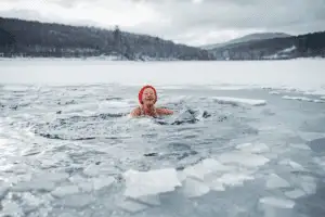 ine ältere Frau beim Eisbaden im See zur Förderung der Longevity und Stärkung des Nervensystems durch Kälteexposition.