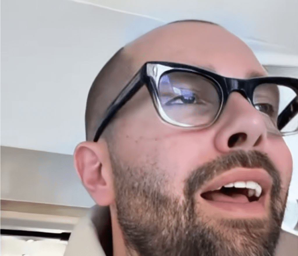 Screenshot aus einem YouTube-Short von Felix Chiropraxie in Hamburg-Altona: Ein erleichterter Patient (Pünti) blickt nach einer erfolgreichen chiropraktischen Justierung fassungslos und glücklich nach oben. Im Vordergrund ist Chiropraktiker Felix eingeblendet.